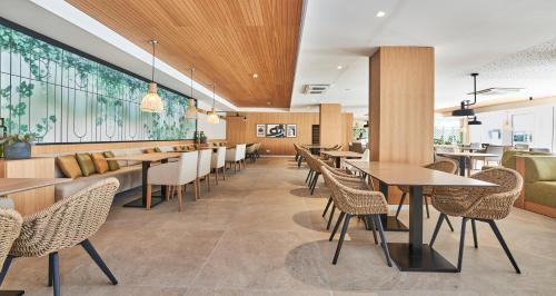 a restaurant with tables and chairs and a bar at Hoposa Hotel & Apartaments VillaConcha in Port de Pollensa