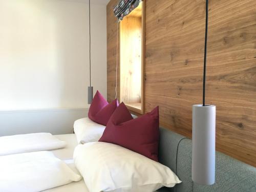 two beds in a room with red and white pillows at Gasthof Fischerstüberl in Rottau