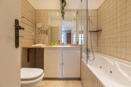 a bathroom with a toilet and a sink and a tub at SALDANHA POMBALINE RESIDENCE in Lisbon