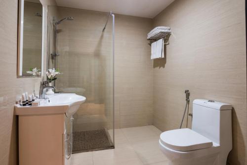 a bathroom with a toilet and a sink and a shower at Naviti Warwick Al Khobar in Al Khobar