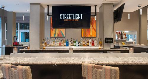 a bar with a large screen above the bar at Holiday Inn & Suites Philadelphia W - Drexel Hill by IHG in Drexel Hill