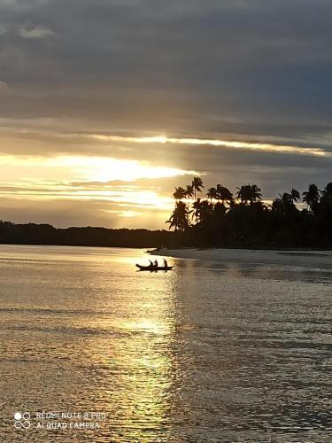 two people in a boat on the water at sunset at Pousada Horizonte Azul in Ilha de Boipeba