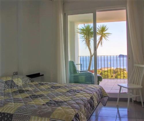 a bedroom with a bed and a balcony with a palm tree at Villamarina dúplex en primera línea de mar - Fincas Arena in Benidorm