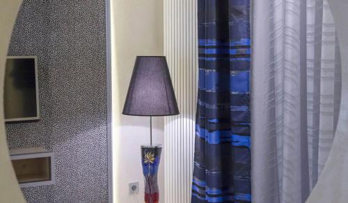 a lamp sitting next to a window next to a curtain at Mini-suites Le Rêve in Kirrwiller
