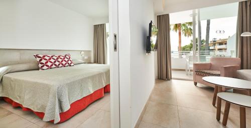a bedroom with a bed and a living room at Hoposa Hotel & Apartaments VillaConcha in Port de Pollensa