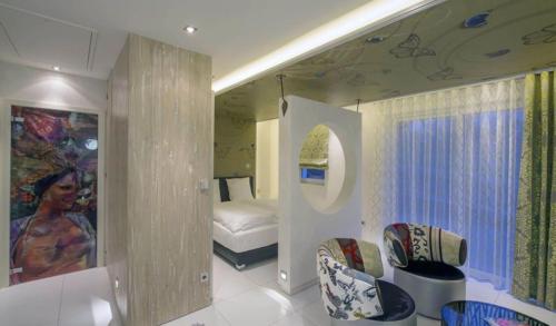 a room with a bedroom with a bed and a mirror at Mini-suites Le Rêve in Kirrwiller