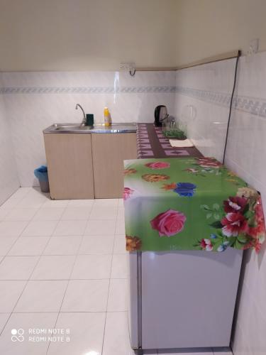 a kitchen with a refrigerator with flowers on it at Pangkor fun fun fun apartment in Pangkor