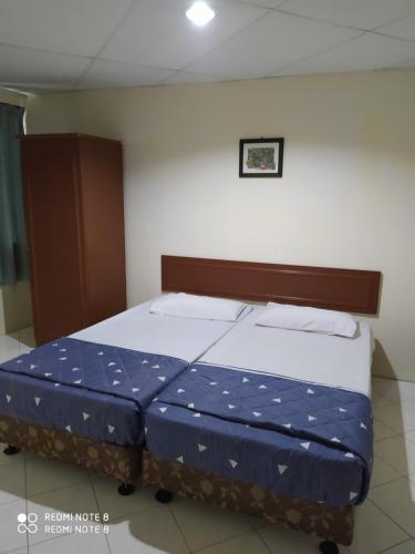 a bedroom with a bed with a blue and white sheets at Pangkor fun fun fun apartment in Pangkor