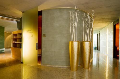 two gold vases with branches in a hallway at Bio & Wellnesshotel Pazeider - Healing Garden above Meran in Marlengo
