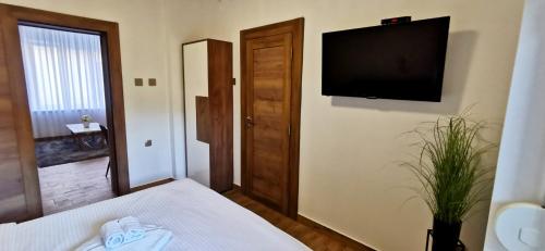 a bedroom with a bed and a flat screen tv at Canti apartments in Novi Sad