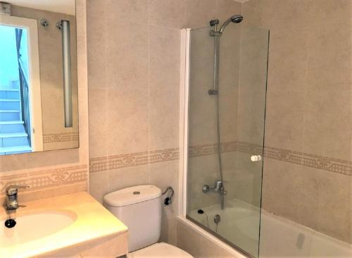 a bathroom with a shower and a toilet and a sink at Villamarina dúplex en primera línea de mar - Fincas Arena in Benidorm