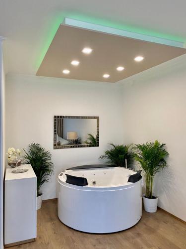 a bath tub in a room with potted plants at Die Oase - Luxurious Apartment near the City Center with Free Parking in Bratislava