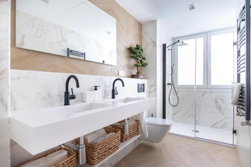 a white bathroom with two sinks and a toilet at Bilbao Sensations.OLD TOWN exclusive views&parking in Bilbao