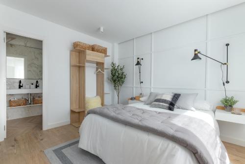 1 dormitorio blanco con 1 cama grande y paredes blancas en Bilbao Sensations.OLD TOWN exclusive views&parking, en Bilbao