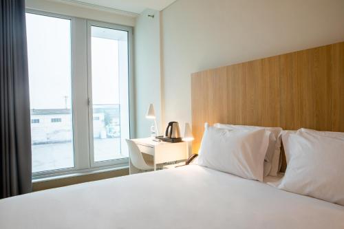 a hotel room with two beds and a window at Stay Hotel Porto Aeroporto in Maia