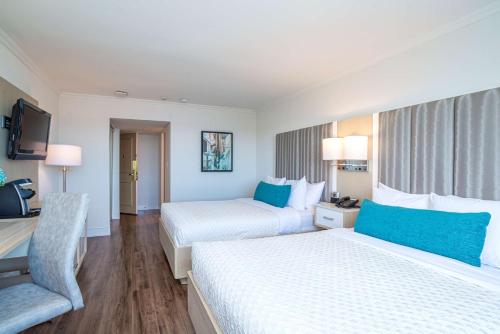 a hotel room with two beds and a chair at Best Western Dorchester Hotel in Nanaimo