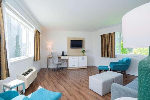 a large living room with a desk and chairs at Best Western Dorchester Hotel in Nanaimo