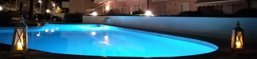 a large swimming pool with blue lights on a building at B&C Apartments LA POSTA Home in Lido di Jesolo