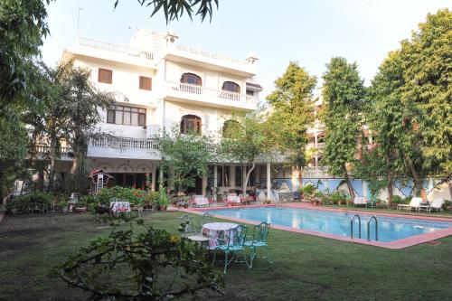a hotel with a swimming pool in front of a building at Hotel Meghniwas in Jaipur
