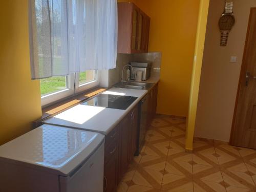 eine Küche mit einem Waschbecken und einem Fenster in der Unterkunft Domek w Górach in Lubawka