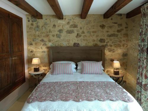 a bedroom with a bed with two lamps on two tables at La Lezardiere in Gourdon-en-quercy