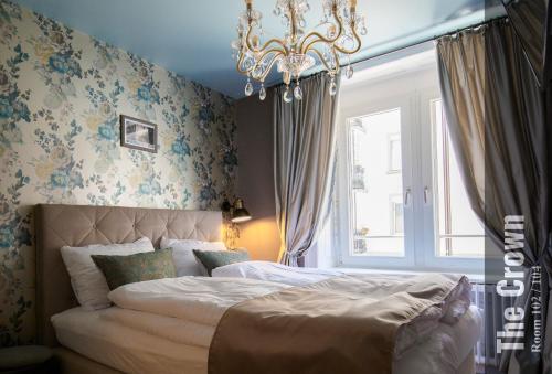 a bedroom with a bed and a chandelier at The Henry Self Check-In Guesthouse in Zürich