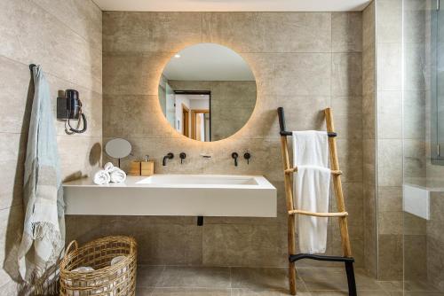 a bathroom with a sink and a mirror at Caldera Theros Villas in Hersonissos