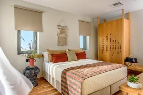 a bedroom with a bed and a clock on the wall at Caldera Theros Villas in Hersonissos