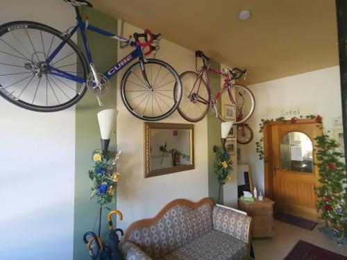 dos bicicletas colgando en la pared en una sala de estar en Hotel Garni Austermayer, en Traunreut