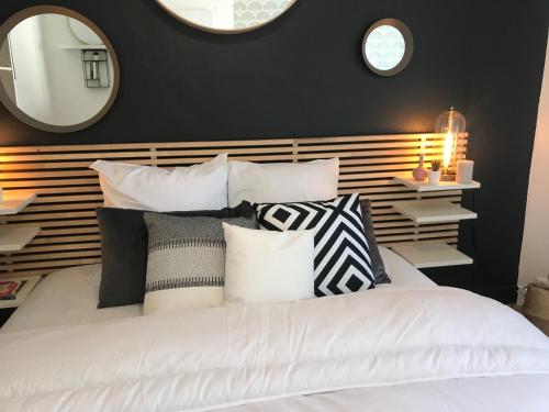 a bedroom with a white bed with black and white pillows at Hullman Suite Apartment 4 People Between La Défense and Paris in Asnières-sur-Seine