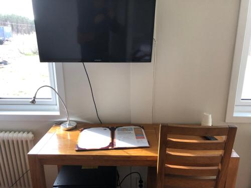 a wooden desk with a television and a book on it at Motoristen in Vara