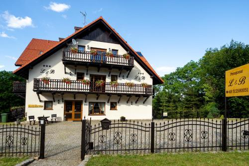 een wit huis met een balkon en een hek bij L&B Spa in Karpacz