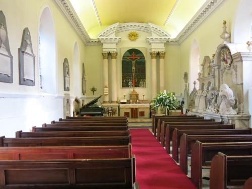 a church with wooden pews and a red carpet at Hazlewood Castle & Spa in Tadcaster