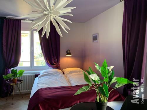 a bedroom with a bed with purple curtains and a chandelier at The Henry Self Check-In Guesthouse in Zürich
