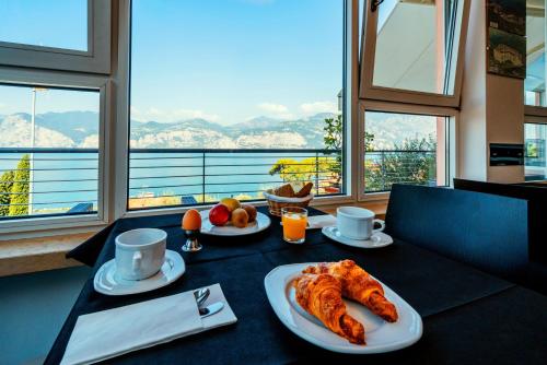 - Mesa con desayuno de cruasanes y zumo de naranja en Hotel Antonella, en Malcesine