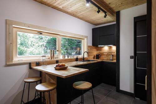 a kitchen with a counter with stools and a window at Mount Apart Sport House in Zakopane