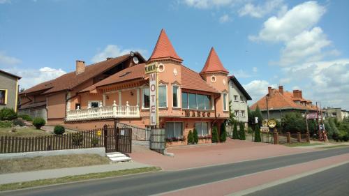 a large house with a gambrel roof on a street at Zajazd Marco Torzym in Torzym