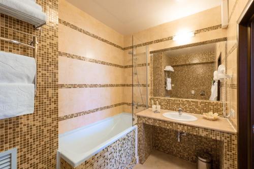 a bathroom with a sink, mirror, and bathtub at Business Hotel Diplomat in Nizhny Novgorod