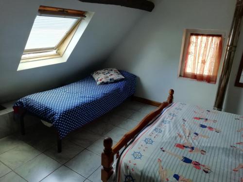 - une petite chambre avec un lit et une fenêtre dans l'établissement La Petite Maison, à Beauchêne