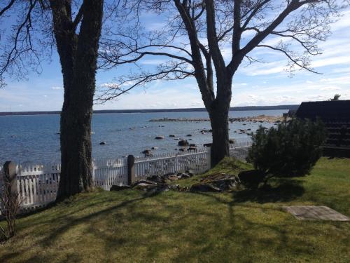 a fence with trees and a view of the water at ÄSSA BEACH HOUSE in Käsmu