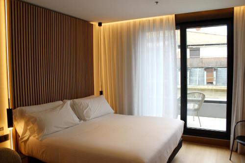 a bedroom with a bed and a large window at Zenit Convento San Martin in San Sebastián