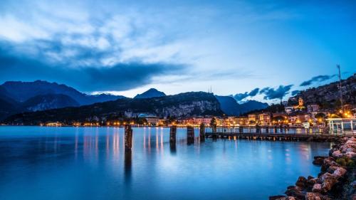 a view of a lake with a town and mountains at Hotel Paradiso Conca d'Oro in Nago-Torbole