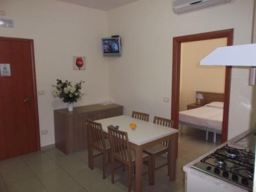 a kitchen with a table and chairs and a bedroom at Residence MILANO in Chieuti