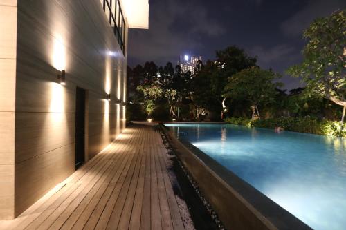 una piscina por la noche junto a un edificio en Veranda Serviced Residence Puri, en Yakarta