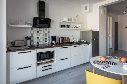 a kitchen with white cabinets and a table at CLASSY APARTMENTS - Gdańsk - Widok z Wyspy in Gdańsk