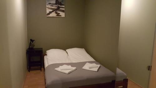 ein kleines Schlafzimmer mit einem Bett mit zwei weißen Handtüchern in der Unterkunft apartament in Posen