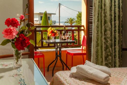 a balcony with a table with a vase of flowers at Eleni Apartments in Roda