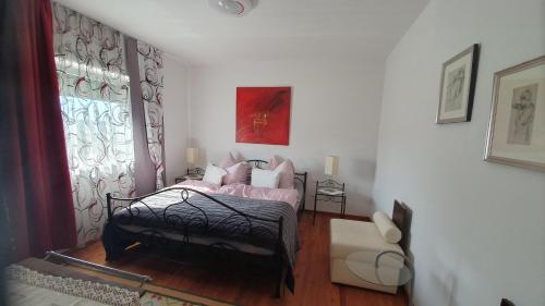 1 dormitorio con cama y ventana en Ferienwohnung Schlossblick 2 oder 5, en Stainz