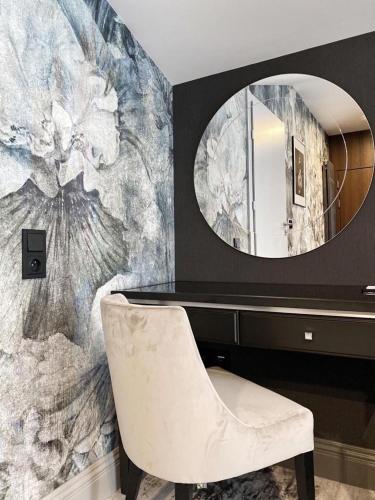 a bathroom with a mirror and a desk and a chair at Hotel & Restauracja Gniecki in Hrubieszów