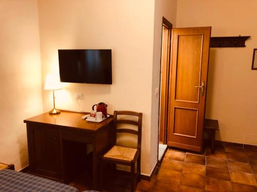 a room with a desk with a chair and a television on the wall at Hotel Nizza in Florence
